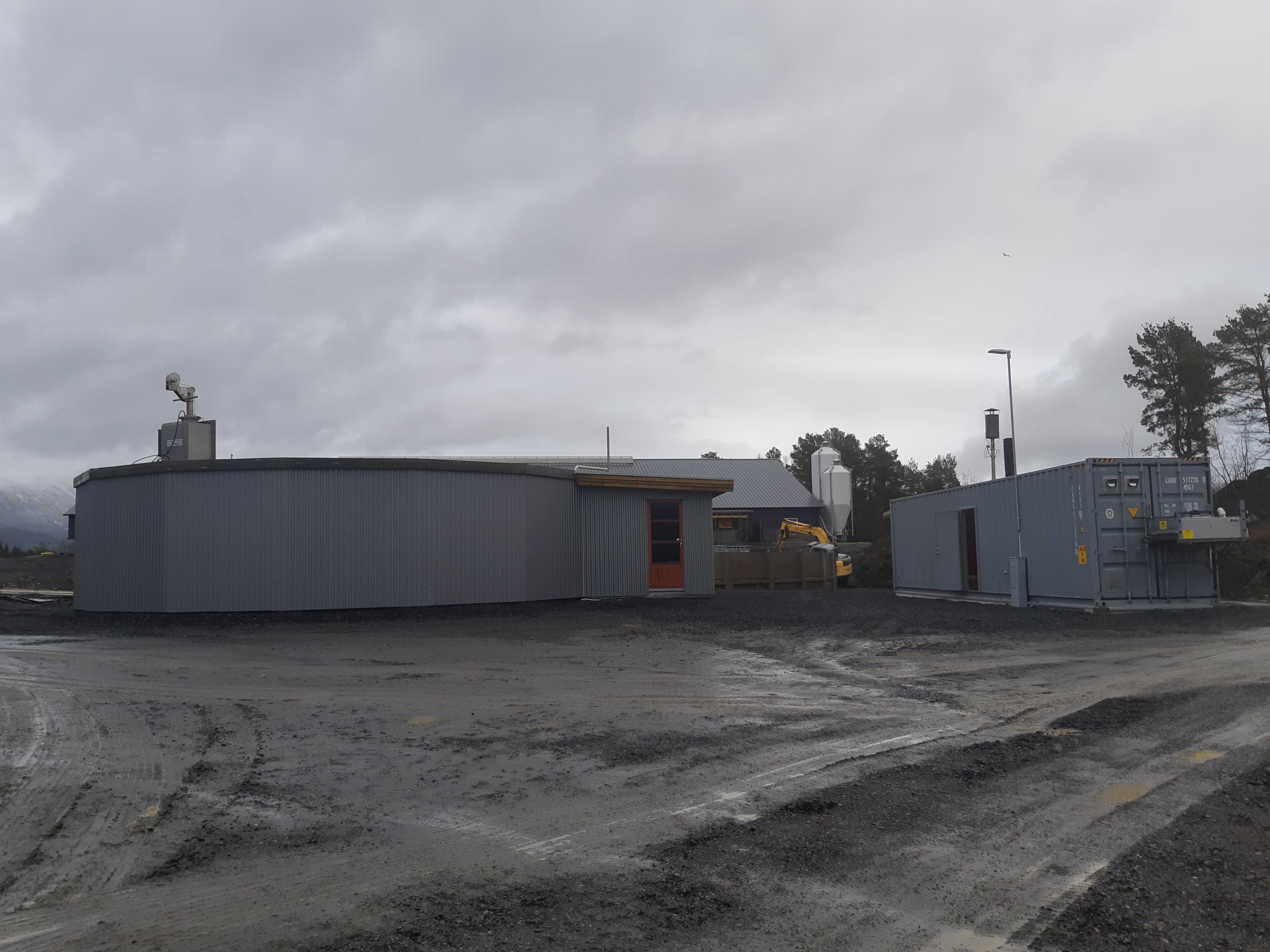 Biogassanlegget på garden til Inge Hoemsnes. Reaktor til venstre i bildet, konteiner med generator og styringssystem til høyre (Foto: Ingvar Kvande)