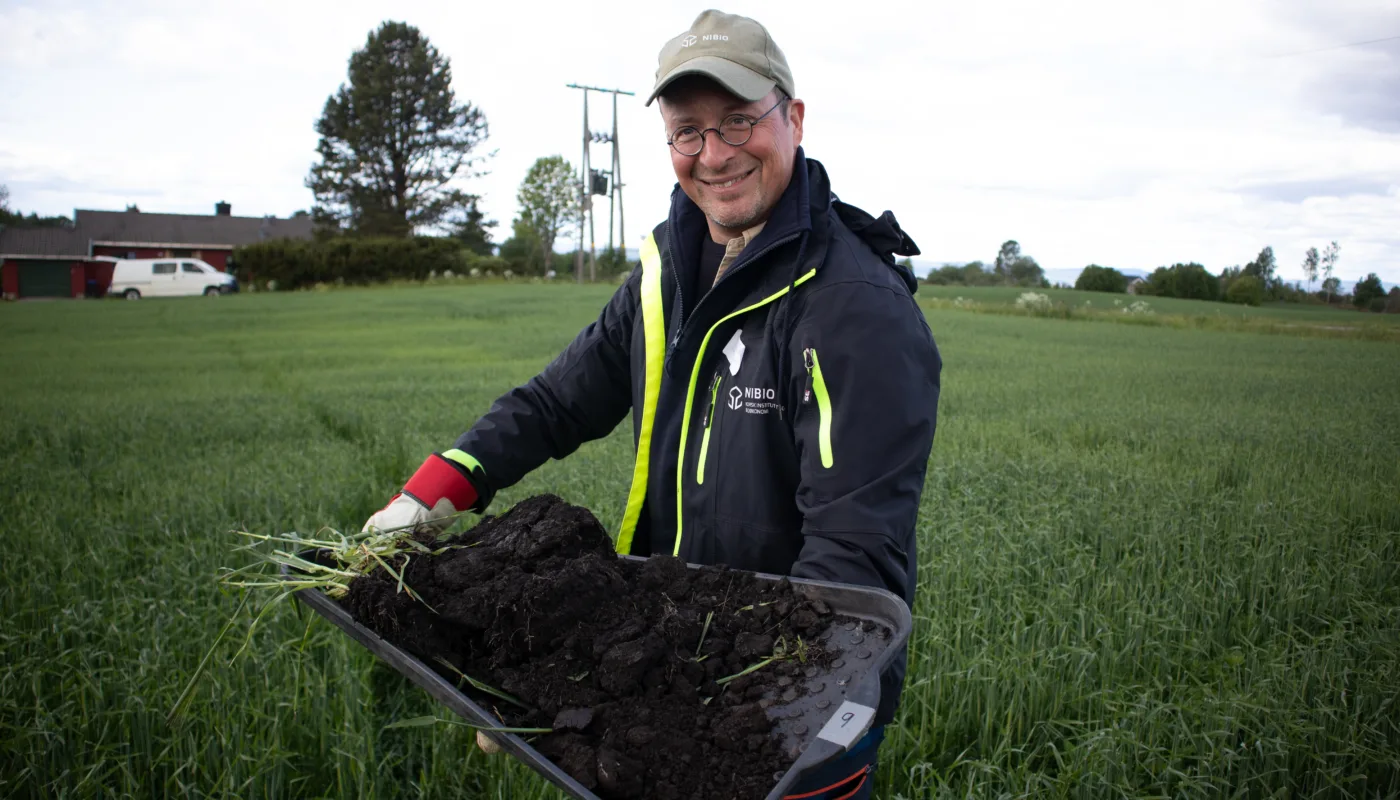 Forsker Till Seehusen (NIBIO) med et lite stykke norsk matjord for vurdering av jordhelse på en av gårdene i prosjektet. (Foto: Tatiana Rittl)